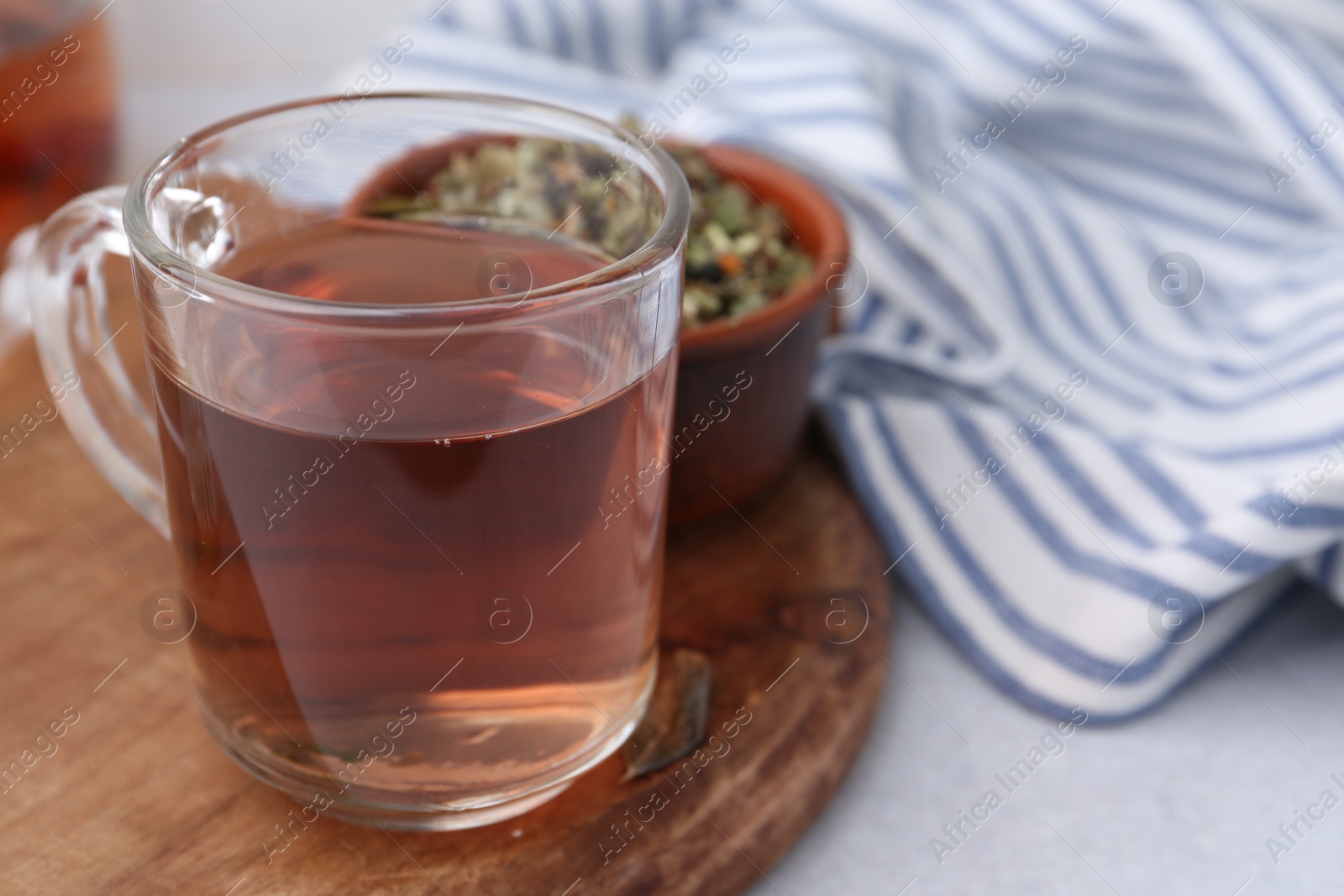 Photo of Delicious herbal tea and dry leaves on white table, closeup. Space for text