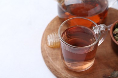 Photo of Delicious herbal tea with honey on white table. Space for text