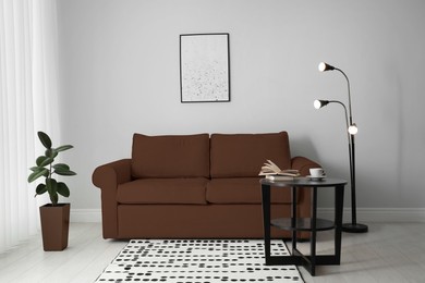 Image of Sofa in mocha mousse shade and decor indoors. Interior with trendy color of 2025 year