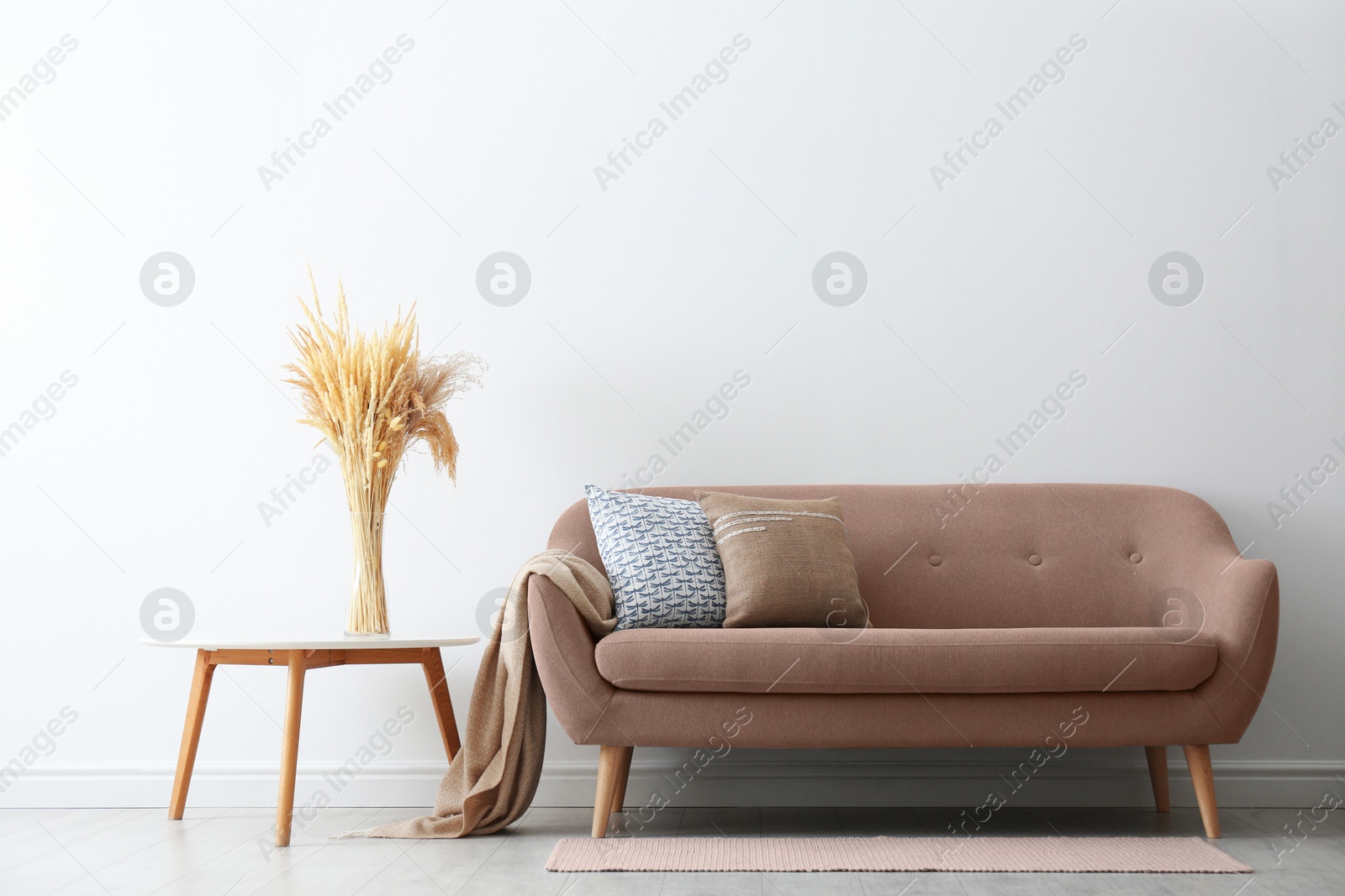 Image of Sofa in mocha mousse shade and decor indoors. Interior with trendy color of 2025 year