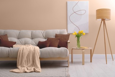 Image of Beige sofa with pillows in mocha mousse shade indoors. Interior design with trendy color of 2025 year