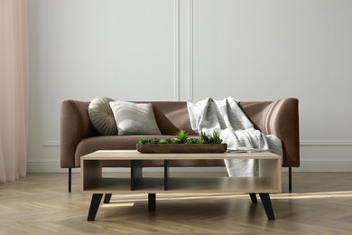 Image of Sofa in mocha mousse shade and table indoors. Cozy living room interior with trendy color of 2025 year