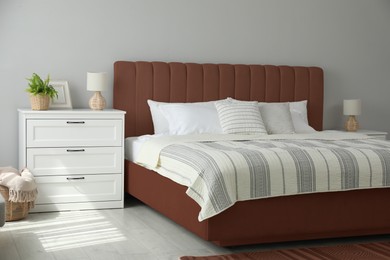 Image of Bed in mocha mousse shade indoors. Cozy bedroom interior with trendy color of 2025 year