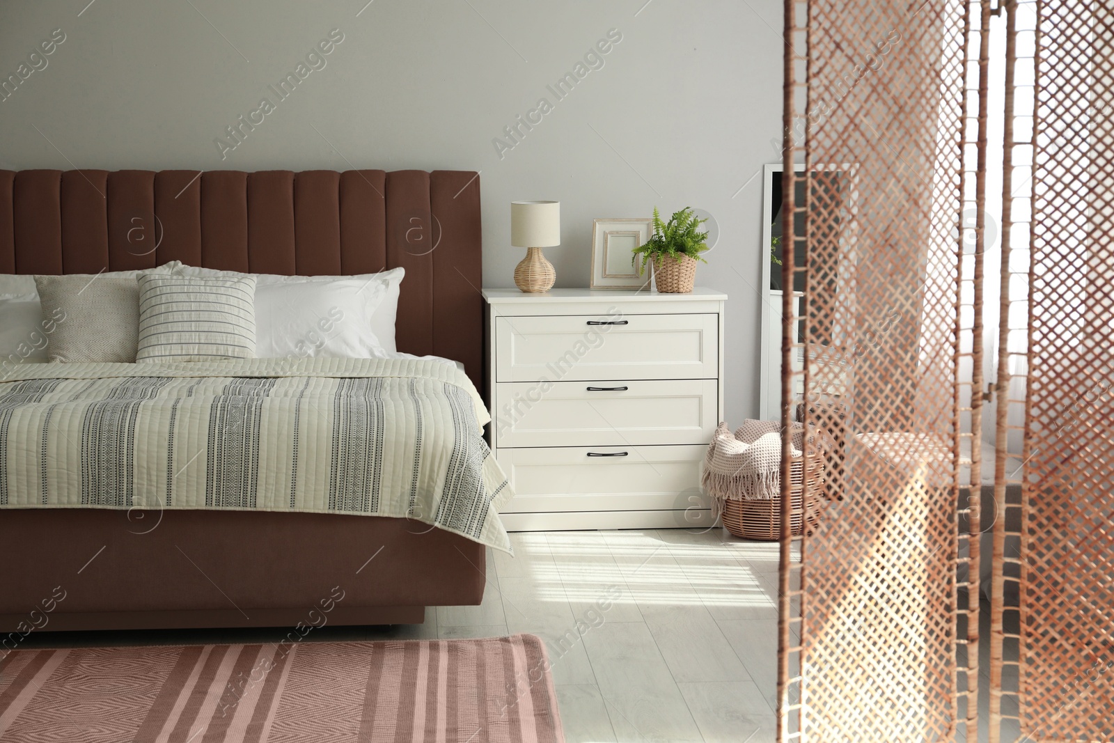 Image of Bed in mocha mousse shade indoors. Cozy bedroom interior with trendy color of 2025 year