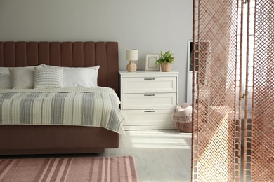 Image of Bed in mocha mousse shade indoors. Cozy bedroom interior with trendy color of 2025 year