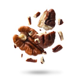 Image of Broken pecan nuts in air on white background