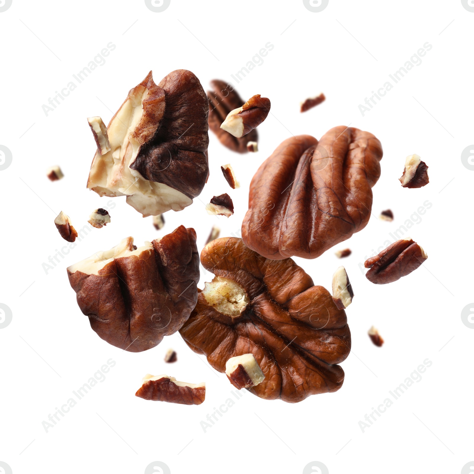 Image of Broken pecan nuts in air on white background