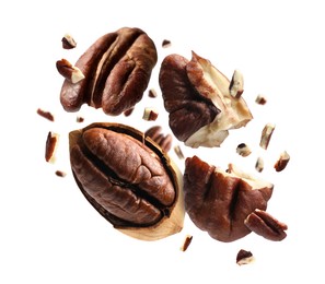 Image of Broken pecan nuts in air on white background