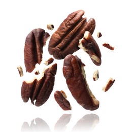 Image of Broken pecan nuts in air on white background