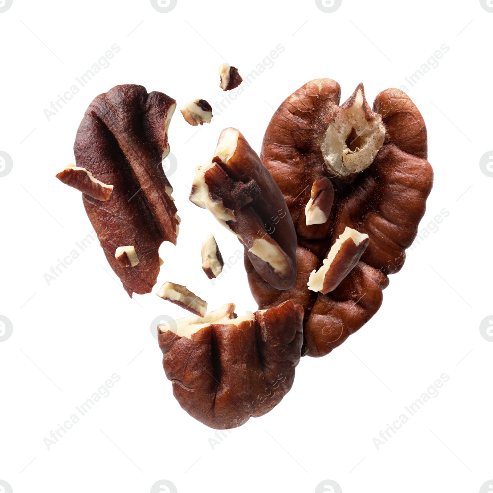 Image of Broken pecan nuts in air on white background