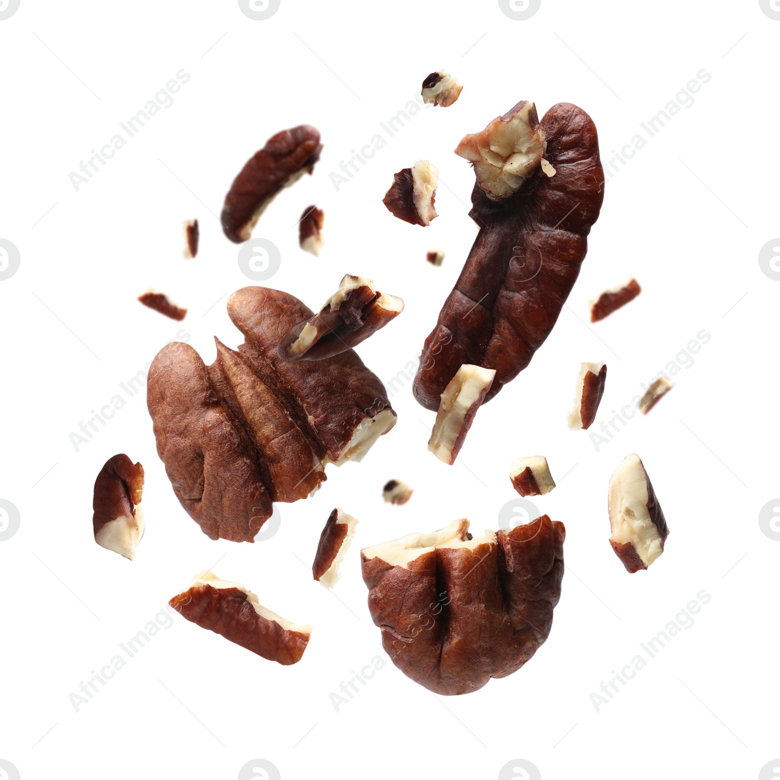 Image of Broken pecan nuts in air on white background