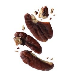 Image of Broken pecan nuts in air on white background