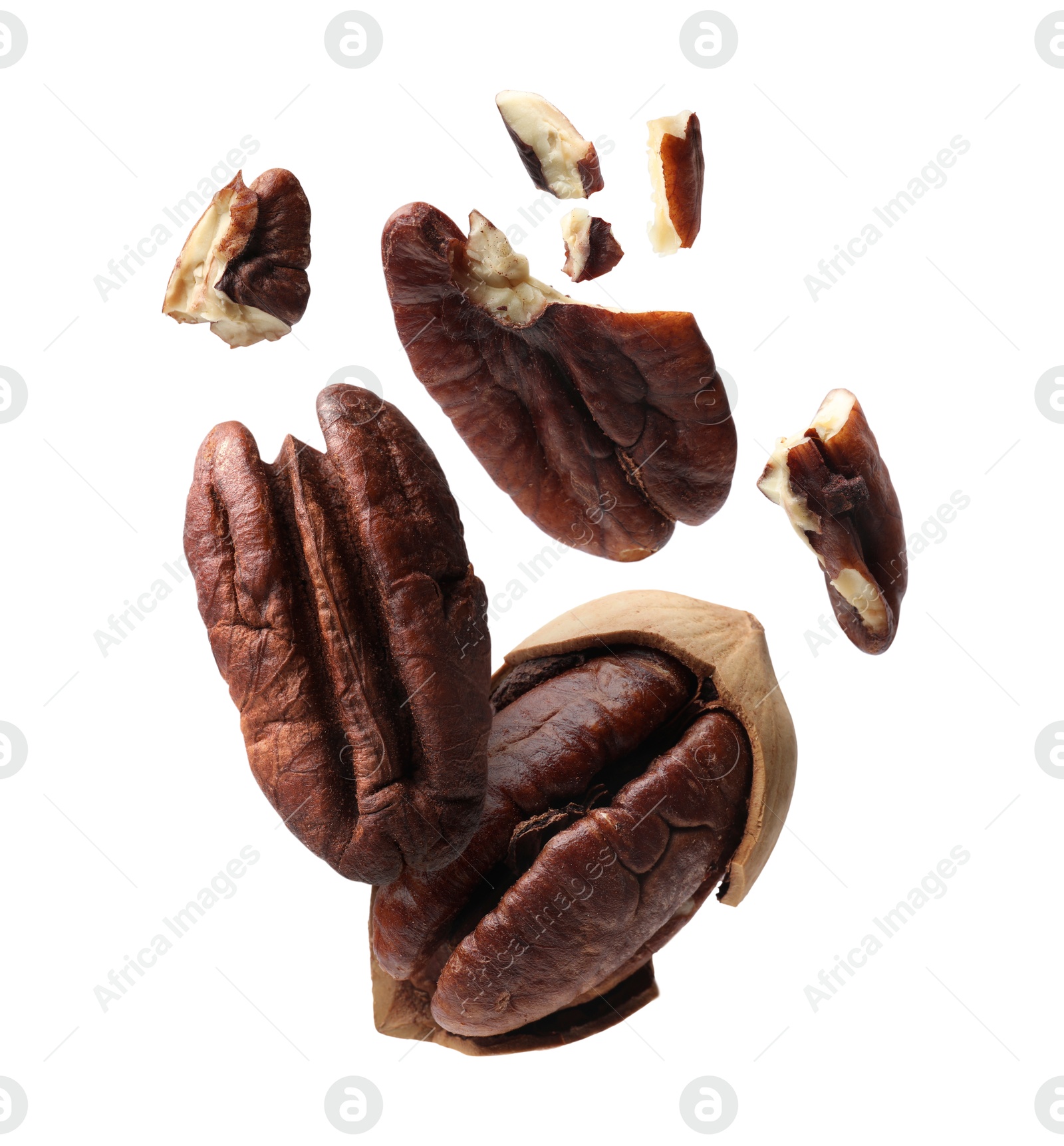 Image of Broken pecan nuts in air on white background