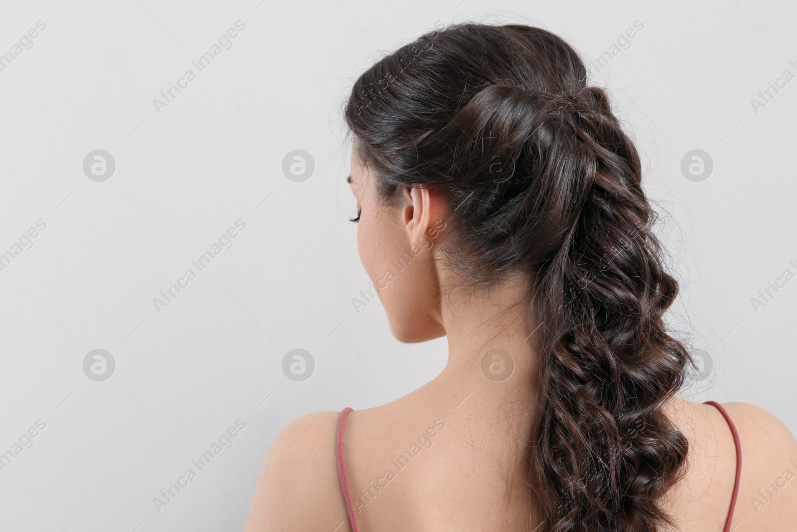 Photo of Young woman with beautiful hairstyle on beige background. Space for text