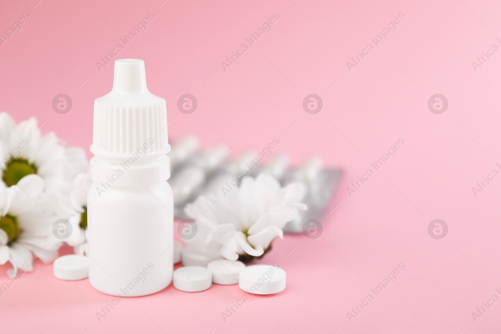 Photo of Allergy treatment. Nasal drops, pills and flowers on pink background, closeup. Space for text