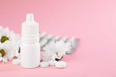 Photo of Allergy treatment. Nasal drops, pills and flowers on pink background, closeup. Space for text