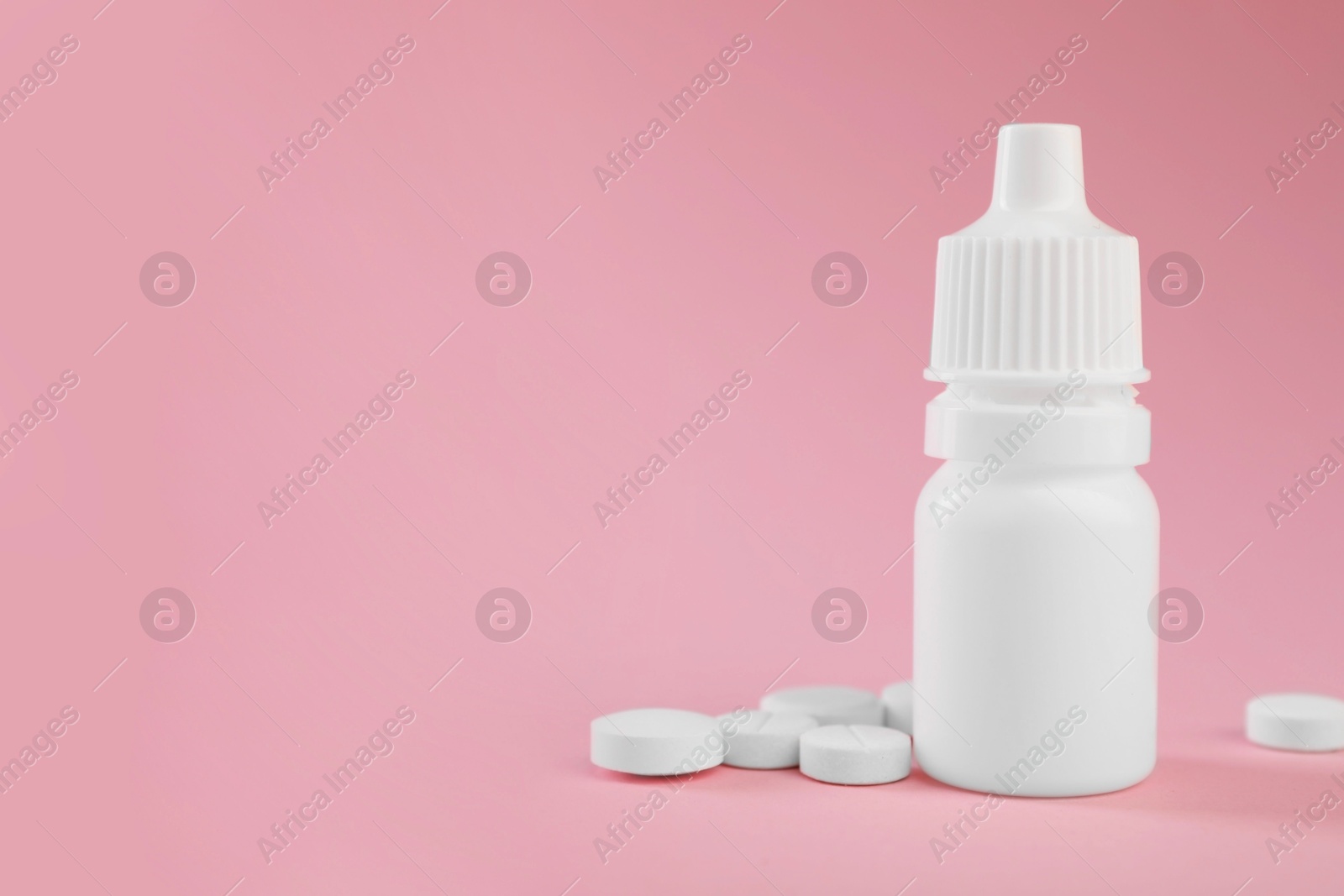 Photo of Allergy treatment. Nasal drops and pills on pink background, closeup. Space for text