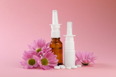 Photo of Allergy treatment. Different medications and flowers on pink background