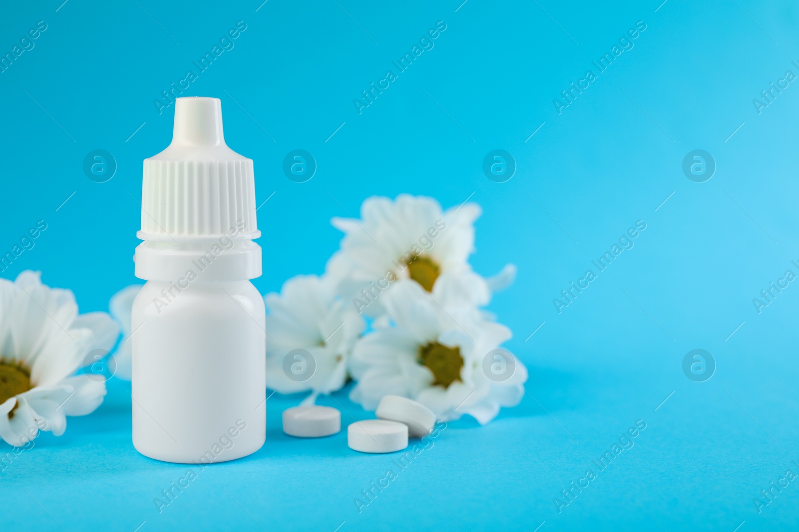 Photo of Allergy treatment. Nasal drops, pills and flowers on light blue background, closeup. Space for text