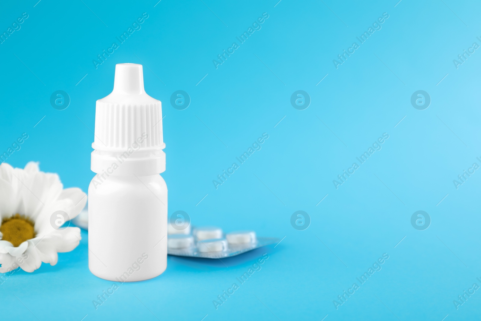 Photo of Allergy treatment. Nasal drops, pills and flower on light blue background, closeup. Space for text