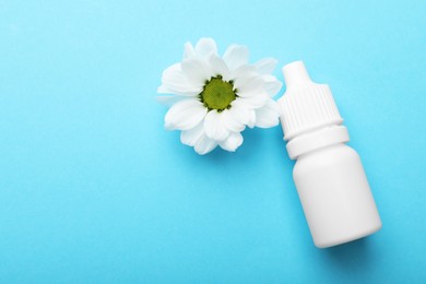 Photo of Allergy treatment. Nasal drops and flower on light blue background, top view. Space for text