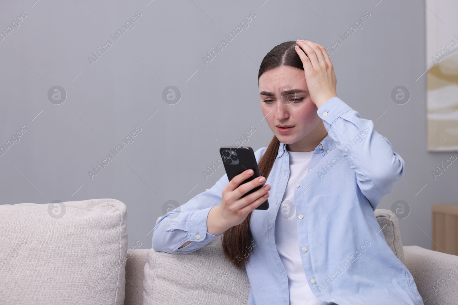 Photo of Depressed woman calling hotline for mental health help on sofa at home. Space for text