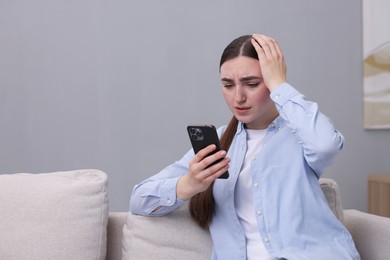 Photo of Depressed woman calling hotline for mental health help on sofa at home. Space for text