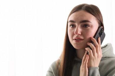 Photo of Desperate woman calling hotline for mental health help on white background. Space for text