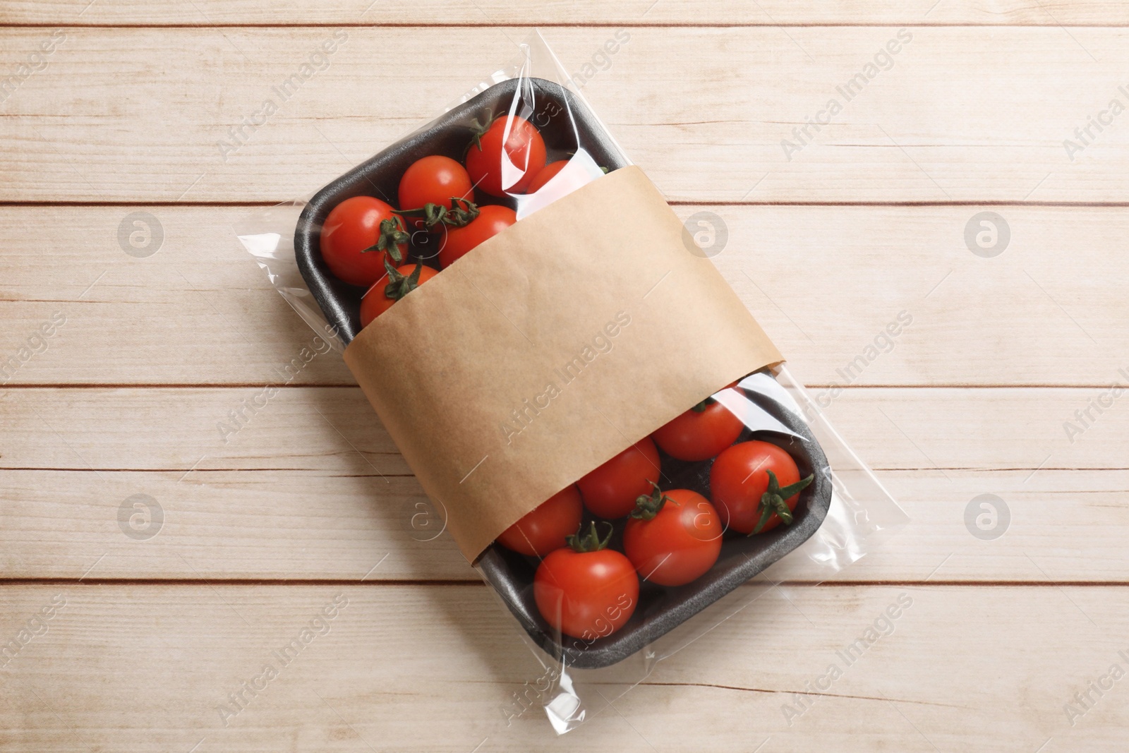 Photo of Pack of fresh tomatoes on wooden table, top view