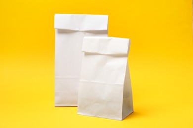 Photo of Two closed paper bags on yellow background