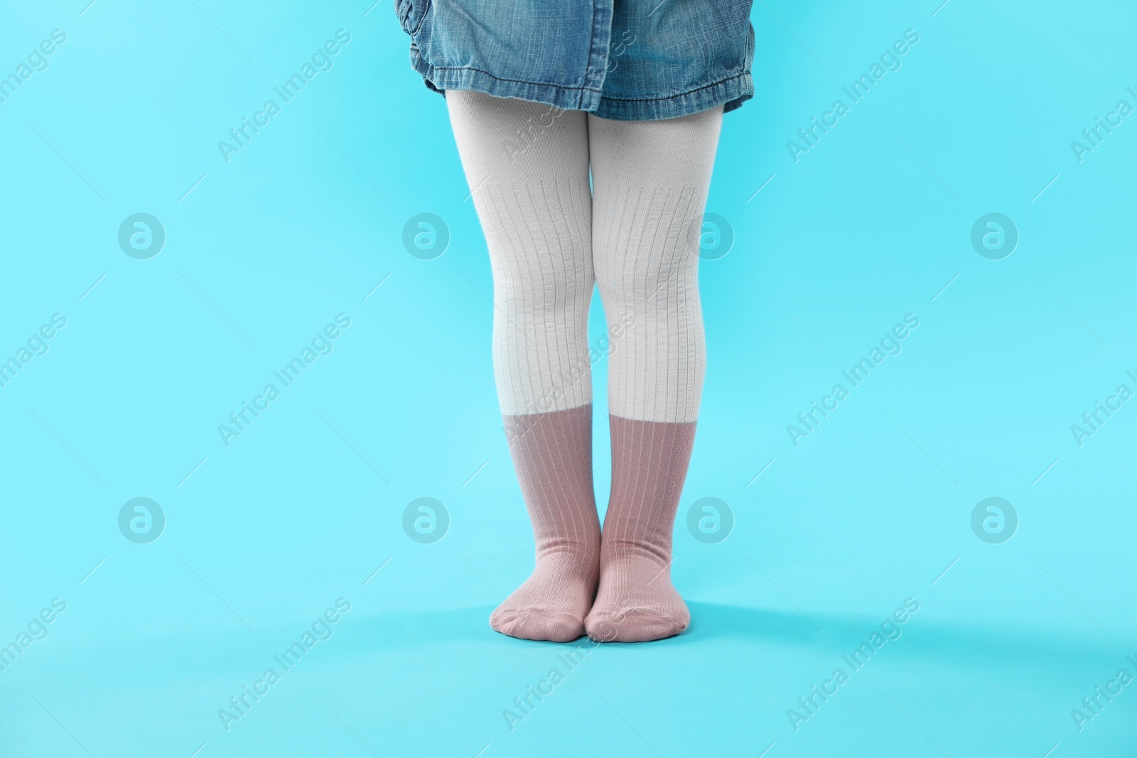 Photo of Child wearing tights on light blue background, closeup