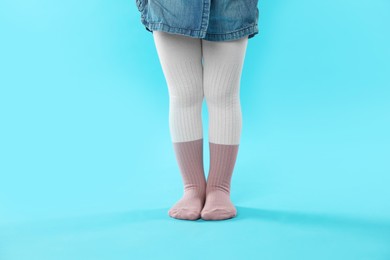 Photo of Child wearing tights on light blue background, closeup