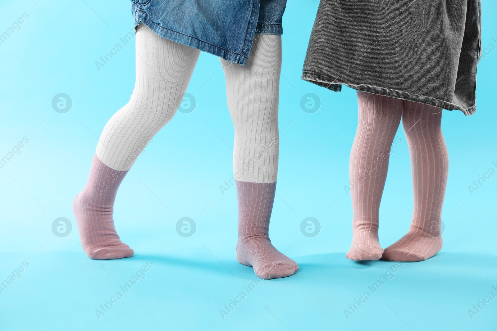 Photo of Kids wearing tights on light blue background, closeup