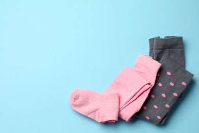 Photo of Different child's tights on light blue background, top view. Space for text