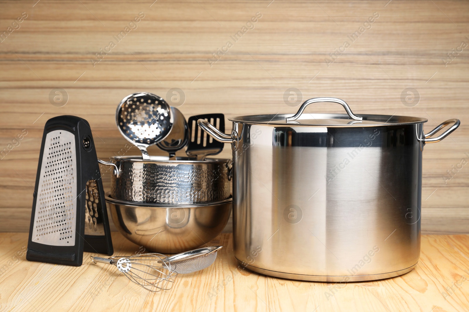 Photo of Dishware and cooking utensils on wooden table