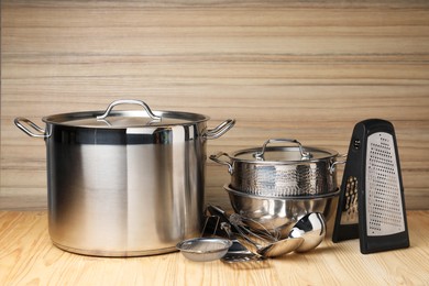 Photo of Dishware and cooking utensils on wooden table