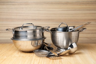 Photo of Dishware and cooking utensils on wooden table