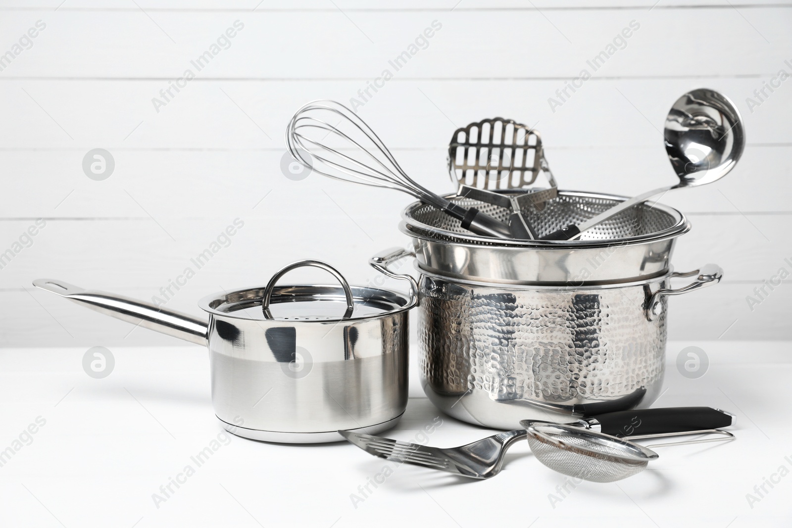 Photo of Dishware and cooking utensils on white table