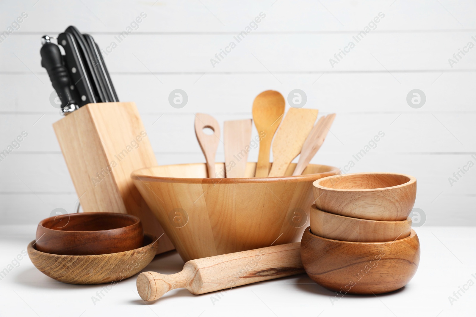 Photo of Dishware and cooking utensils on white table