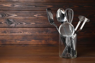 Photo of Set of cooking utensils on wooden table, space for text