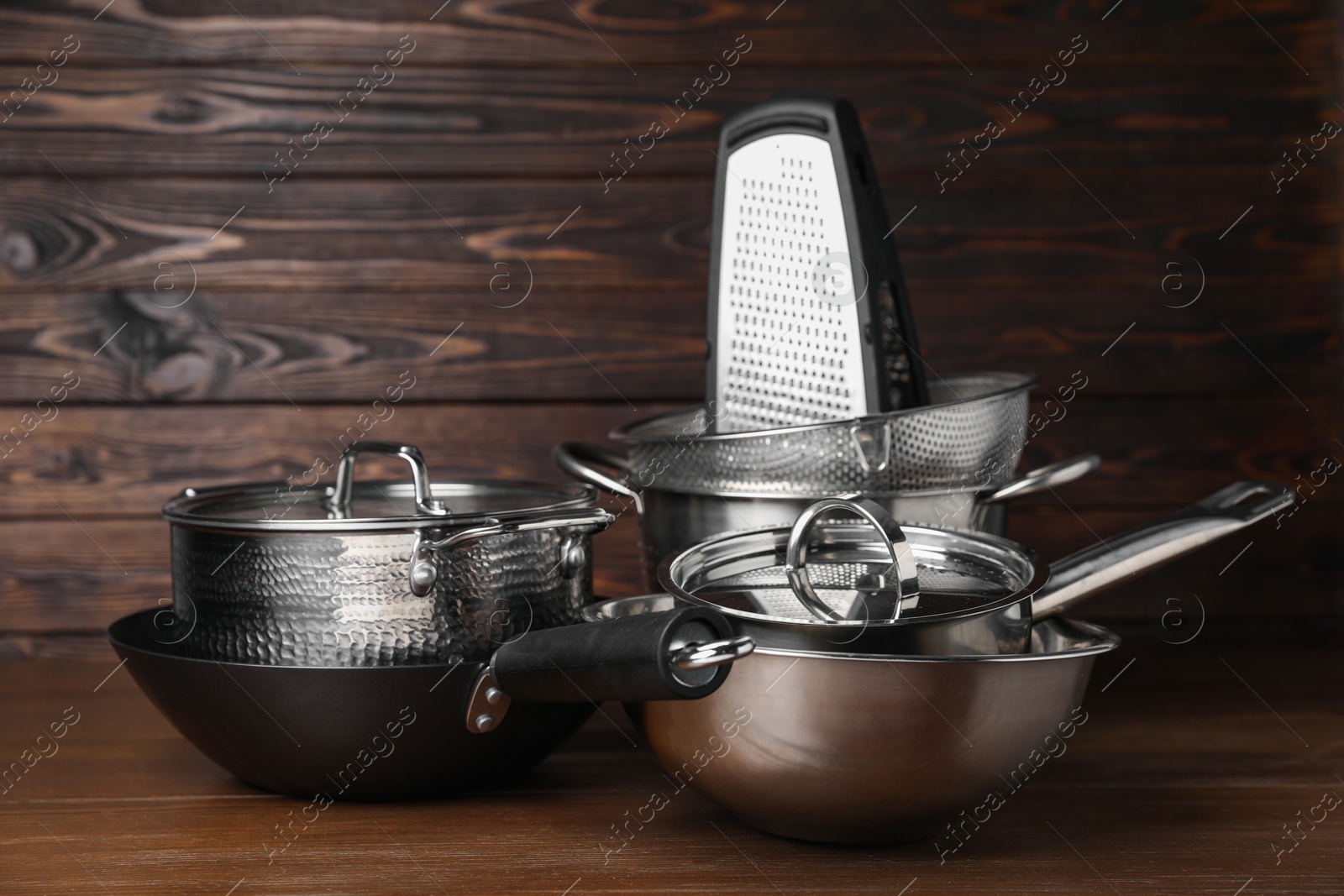 Photo of Dishware and cooking utensils on wooden table