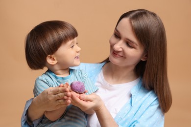 Photo of Mother and baby eating tasty mochi on brown background