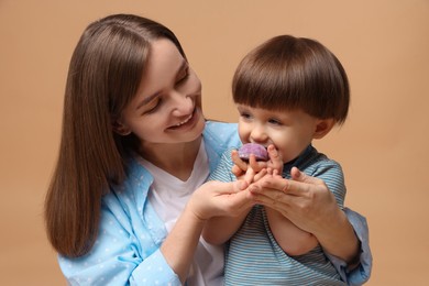 Photo of Mother and baby eating tasty mochi on brown background