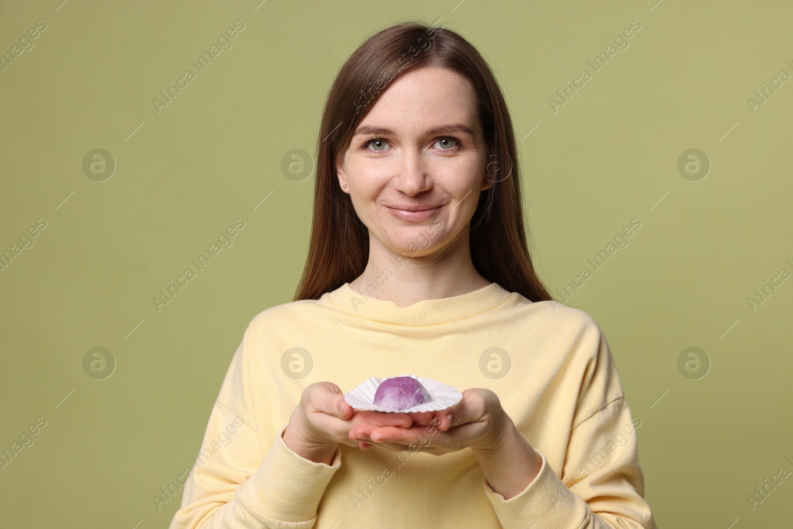 Photo of Woman with tasty mochi on olive background