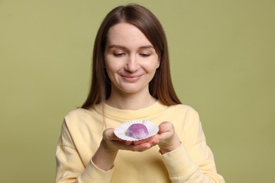 Photo of Woman with tasty mochi on olive background