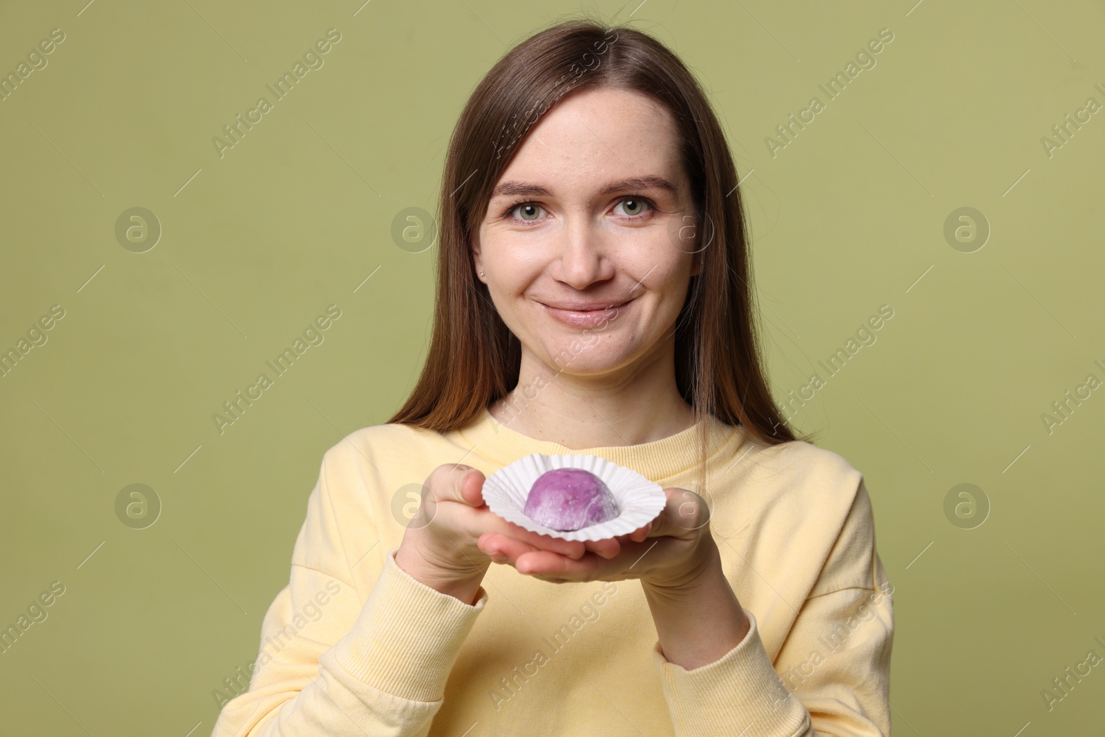 Photo of Woman with tasty mochi on olive background