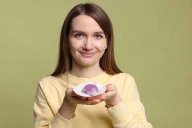 Photo of Woman with tasty mochi on olive background