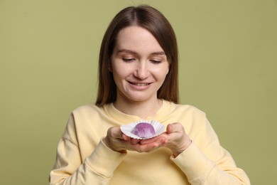 Photo of Woman with tasty mochi on olive background