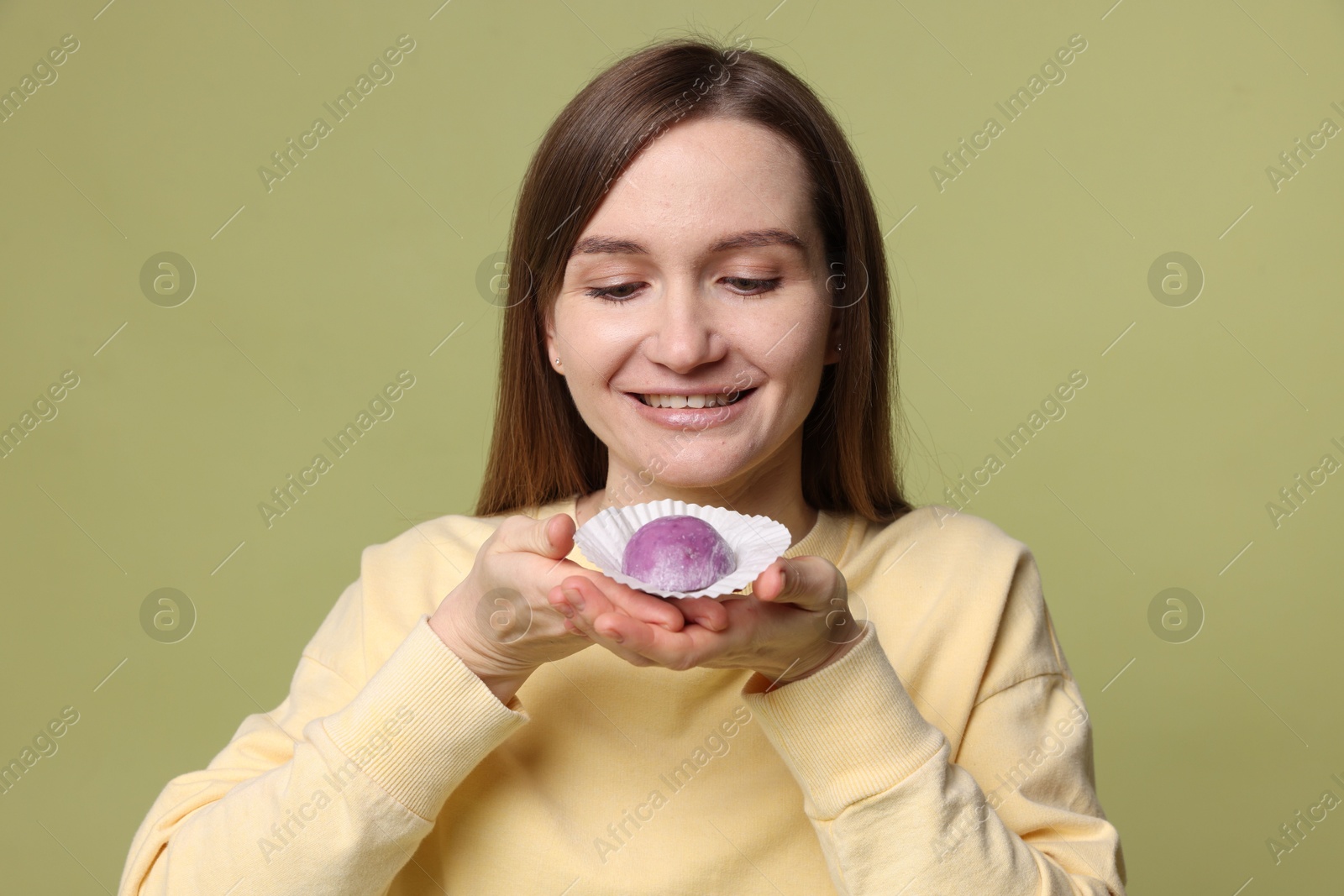 Photo of Woman with tasty mochi on olive background