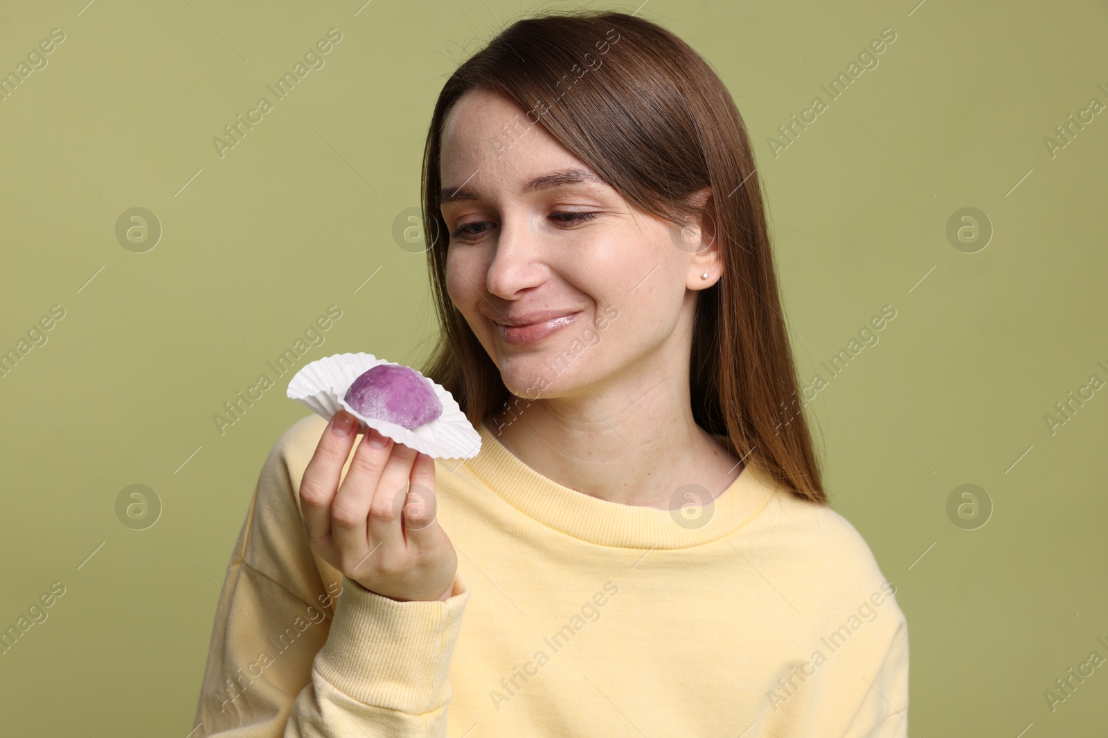 Photo of Woman with tasty mochi on olive background